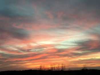 Low angle view of silhouette trees against romantic sky