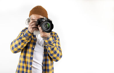 Man photographing against white background