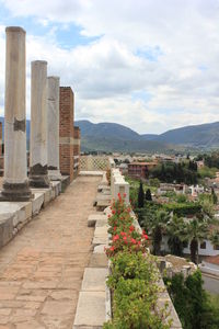 Architectural columns at old ruins against cloudy sky