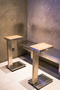 Empty bench on table against wall