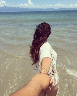 Rear view of woman standing at beach