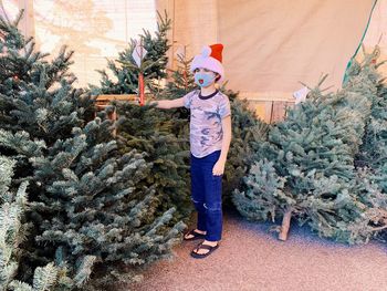 Full length of man standing in christmas tree