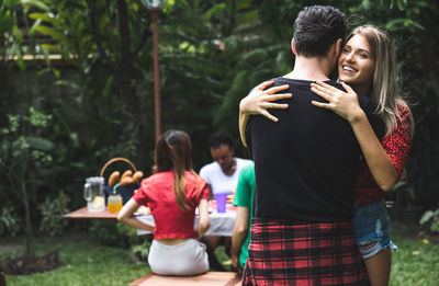 Smiling woman embracing man in park