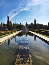 Pond at jardins de belem against sky on sunny day