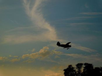 Low angle view of silhouette bird flying against sky during sunset