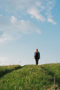 Woman standing on field against sky