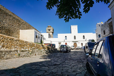 Street amidst buildings against blue sky