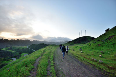 Rear view of people riding bicycle on mountain road