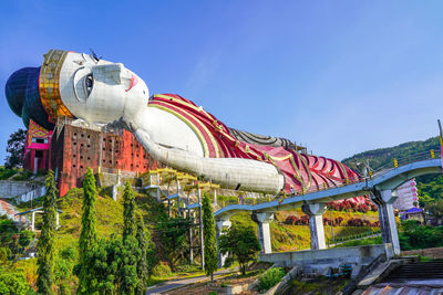 Low angle view of chain swing ride against clear blue sky