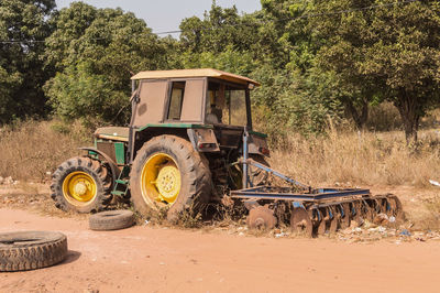 Tractor on road by agricultural field