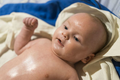 Close-up of cute baby boy on bed