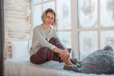 Woman sitting by window at home