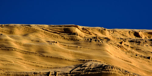 Scenic view of desert against clear blue sky