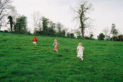Children playing on field against sky