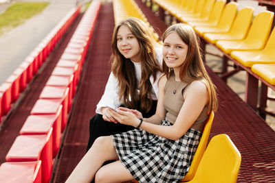 Teenage girls relax together in the school stands. the concept of friendship and relationships