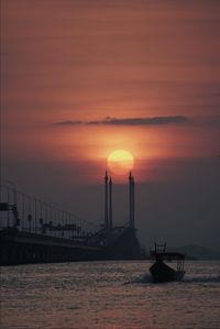 Silhouette ship on sea against sky during sunset