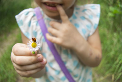 Midsection of woman holding flower