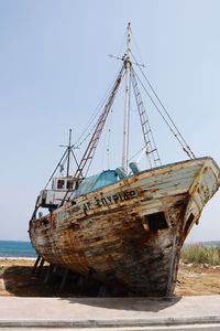 Abandoned ship in sea against clear sky