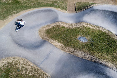 Woman practicing skateboarding at pump track on sunny day