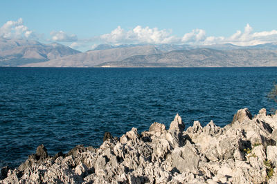 Scenic view of sea and mountains against sky