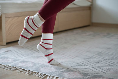 Low section of woman standing on tiled floor at home