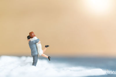 Young woman standing in sea against sky during sunset