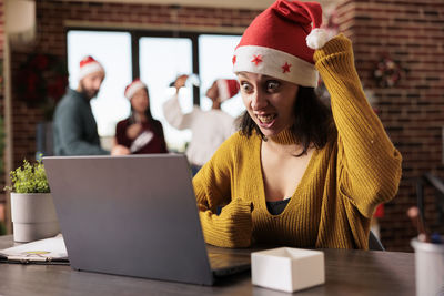 Portrait of woman using laptop while sitting on table