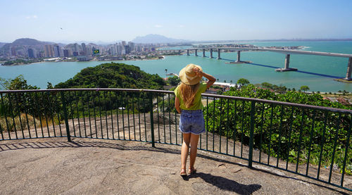 Woman enjoying vitoria cityscape with terceira ponte bridge, vitoria, espirito santo, brazil.