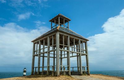 Low angle view of built structure on beach against blue sky