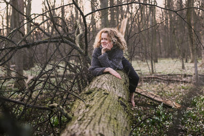 Curly haired lady resting on tree trunk scenic photography