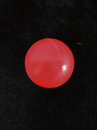 High angle view of red balloon against black background