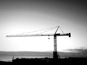 Silhouette of cranes at construction site