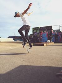 Low angle view of man jumping against sky