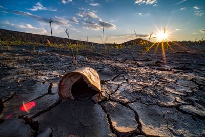 View of rock on land against sky during sunset