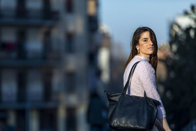 Portrait of woman standing in city