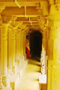 Rear view of man sitting in corridor