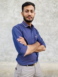 Portrait of young man standing against white background