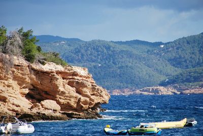 Scenic view of sea and mountains against sky