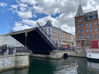Bridge over river against buildings in city