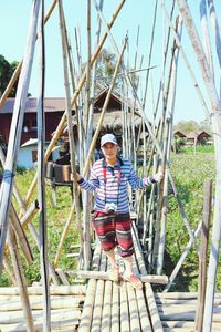 Full length portrait of woman standing on bamboos