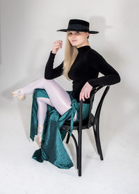 Woman wearing hat while sitting on seat