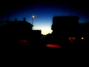 Silhouette buildings against sky at night