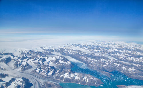 Scenic view of snowcapped mountains against blue sky