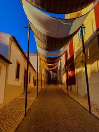 Empty street amidst buildings against sky