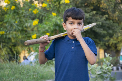 Portrait of boy coughing and holding bat