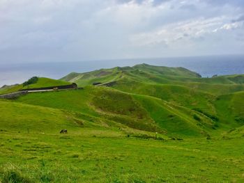 Scenic view of green landscape against sky