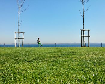 Full length of woman standing on field against clear sky