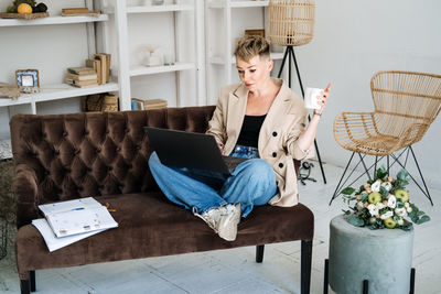 Start own business. young trendy woman planning new project with papers and laptop in home office