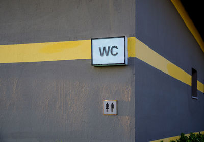 Close-up of arrow sign on wall