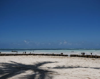 Scenic view of beach against clear blue sky